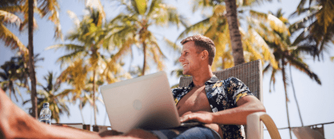 man on vacation booking a flight on laptop